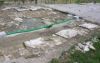 Aquileia, foro romano, settore occidentale: veduta generale da Ovest della fascia settentrionale, in primo piano i basamenti dei pilastri del portico, quindi la platea con le lastre residue e la preparazione in mattoni; a destra (Sud) il settore